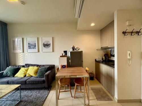 uma cozinha e uma sala de estar com um sofá e uma mesa em Unixx South Pattaya High speed Sea View by May’sa em Ban Hui Yai Muk