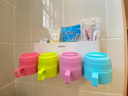 four colorful stools sitting on a shelf in a bathroom at 139 Homestay 13 Mins From kuching Airport Baby Friendly Spacious Home in Kota Samarahan