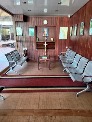 a waiting room with three chairs and a table at Rays Inn Thekkady in Thekkady
