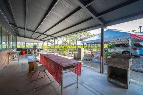 a patio with a table and a grill and a blue umbrella at Along the River B&B in Dongshan