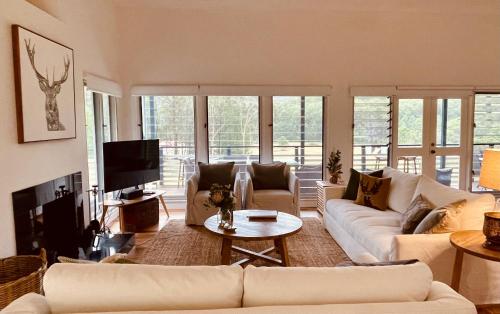 a living room with white couches and a tv at Laguna Valley Country Retreat in Laguna