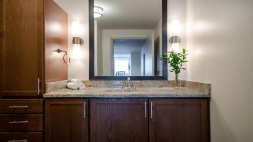 La salle de bains est pourvue d'un lavabo et d'un miroir. dans l'établissement 16th FL Bold CozySuites with pool, gym, roof #3, à Dallas