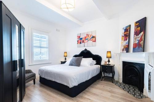 a white bedroom with a bed and a fireplace at Waterfront - KING Master 4 Bedroom 3 Storey#9-10 in Sydney