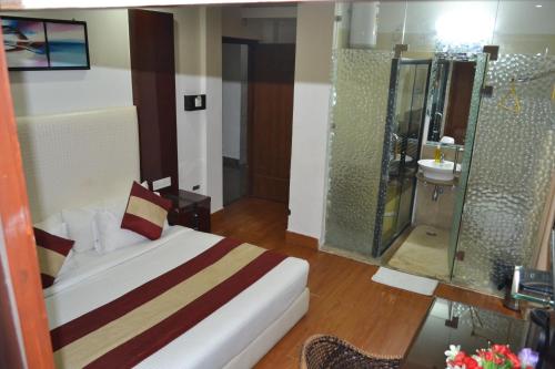 a hotel room with a bed and a shower at Ganga Exotica in Haridwār