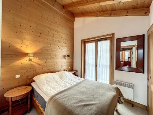 une chambre avec un lit dans une pièce en bois dans l'établissement Appartement 3 pièces proche pistes à Combloux avec parking - FR-1-560-117, à Combloux