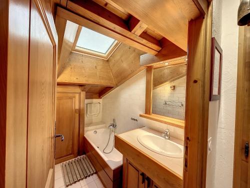 La salle de bains est pourvue d'un lavabo, d'une baignoire et d'une fenêtre. dans l'établissement Appartement 3 pièces proche pistes à Combloux avec parking - FR-1-560-117, à Combloux