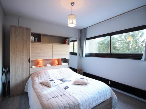 une chambre avec un grand lit et une grande fenêtre dans l'établissement Bel Appartement T2 avec Balcon et Wifi au Mont-Dore - FR-1-608-267, à Le Mont-Dore