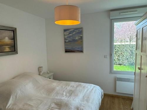 une chambre avec un lit et une fenêtre dans l'établissement Appartement Moderne T2, Rez-de-Jardin, Proche Plage et Centre Ville, Parking, Wifi, Animaux Acceptés - FR-1-487-362, à Cabourg