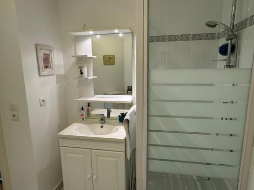 een witte badkamer met een wastafel en een douche bij Appartement Cabourg, 2 pièces, 4 personnes - FR-1-487-266 in Cabourg