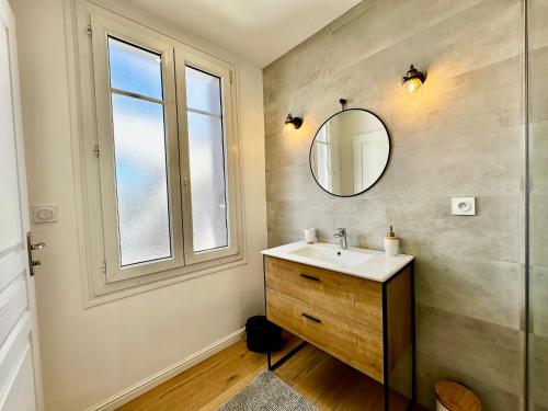 une salle de bain avec un lavabo et un miroir dans l'établissement Maison grand confort à Doëlan, vue mer, accès chemins côtiers et plage, WIFI, parking - FR-1-714-12, à Clohars-Carnoët