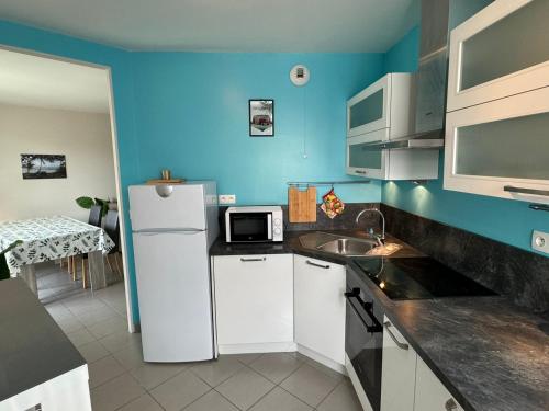 une cuisine avec un réfrigérateur blanc et un évier dans l'établissement Appartement Moderne près de la Plage et du Centre - 2 Chambres, Balcon, Parking, Animaux Acceptés - FR-1-487-363, à Cabourg