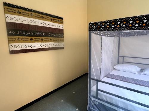 um quarto com uma cama e uma fotografia na parede em Renovated Gem on the island em Saint-Louis