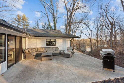 eine Terrasse mit einem Sofa und einem Grill in der Unterkunft RiverEdge Haven Hot Tub, 5 Beds, Kayaks Near ND in Niles