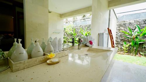 a bathroom with white vases sitting on a counter at Jivana Resort in Kuta Lombok