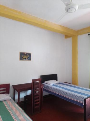 1 dormitorio con 2 camas individuales y escritorio en Our Little Secret, en Kalutara