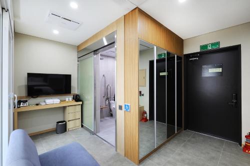 a bathroom with a sliding glass door and a television at The Stay Classic Hotel Myeongdong in Seoul