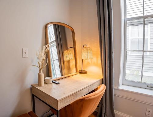 a dressing table with a mirror and a lamp on it at Remodeled Modern Home - private backyard & games! in Louisville