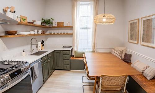 a kitchen with green cabinets and a wooden table at Remodeled Modern Home - private backyard & games! in Louisville