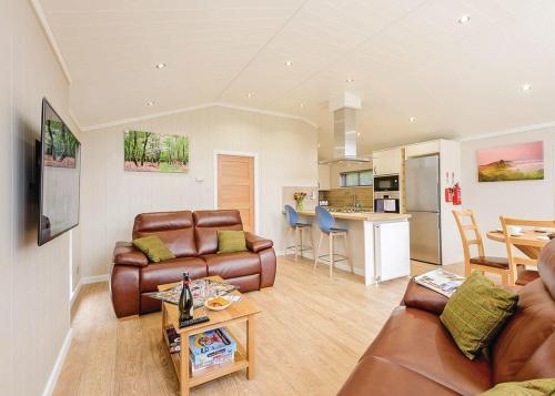 a living room with a couch and a table at Wareham Forest Lodge Retreat in Lytchett Minster