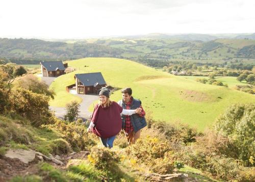 a man and a woman walking down a hill at Slate House Lodges in Llandinam