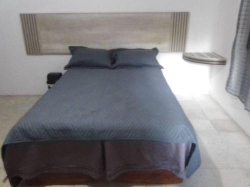 uma cama com um edredão azul num quarto em Casa completa familiar, dos cuartos. em San Agustin de las Juntas