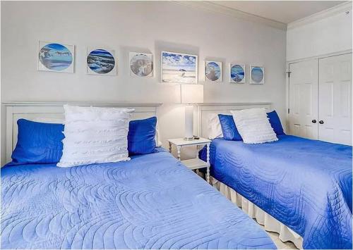 2 camas en una habitación de color azul y blanco en Coligny Beach, Pools, & Shops- Few Steps Away, en Hilton Head Island
