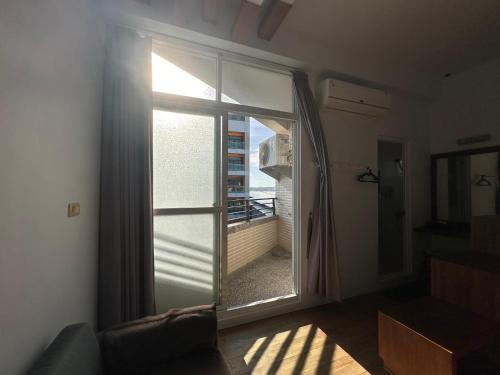 a room with a window with a view of a balcony at Snore Inn in Hengchun