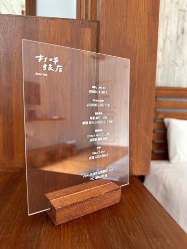 a glass plaque on top of a wooden table at Snore Inn in Hengchun