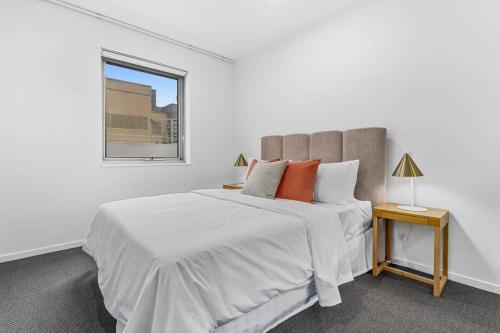 Un dormitorio blanco con una cama grande y una ventana en Regent Residence on Collins with Free WiFi en Melbourne