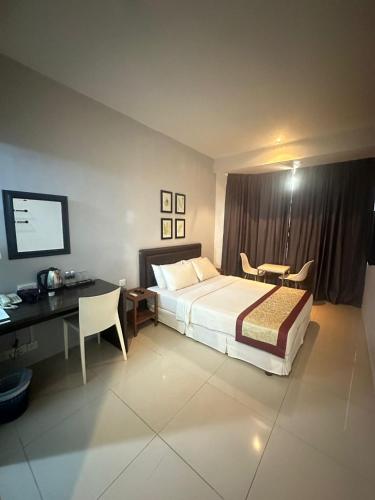 a hotel room with a bed and a desk and a computer at KINGSMAN BOUTIQUE HOTEL in Kota Kinabalu