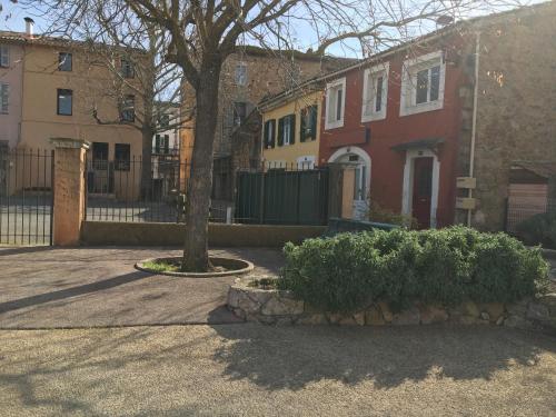 a group of houses with a tree and a fence at Appartement climatisé 1 à 4 personnes avec belle terrasse in Vidauban