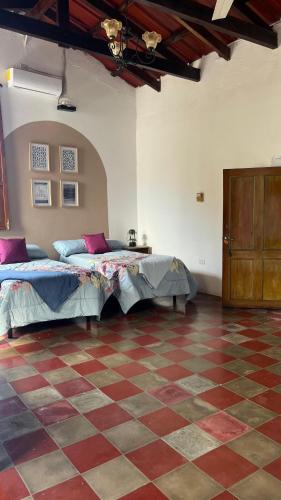 a bedroom with two beds and a checkered floor at Donde Polo Hostal in Suchitoto