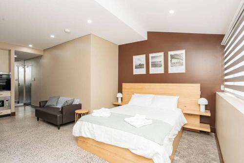 een slaapkamer met een groot bed en een stoel bij NEW! Ideal 1BR Unit in the Hot Spot of Surry Hills in Sydney