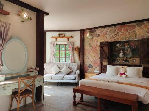 een slaapkamer met een bed, een bureau en een stoel bij Swiss Hotel Pattaya in Sattahip