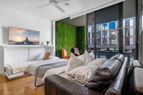 een slaapkamer met een bank en een bed in een kamer bij Brisbane Luxury Gabba Apartment in Brisbane