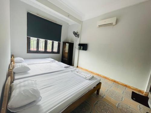 een slaapkamer met 2 bedden en een raam bij CHUNG BẰNG MOTEL in Hương Hóa