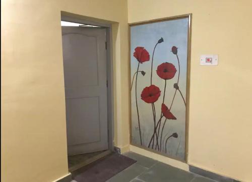 a hallway with a door with red flowers painted on it at Well-equipped modern flat with 24/7 security in Srinagar