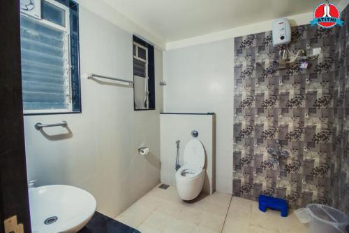 a bathroom with a toilet and a sink at Atithi Service Apartment in Pune