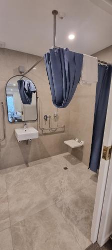 a bathroom with a sink and a mirror at New Orleans Hotel in Arrowtown