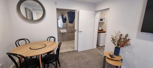 a dining room with a table and chairs and a mirror at New Orleans Hotel in Arrowtown
