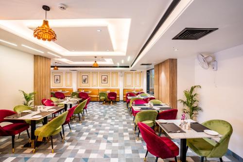 a restaurant with tables and chairs in a room at Regenta Place Raaj Agra in Agra