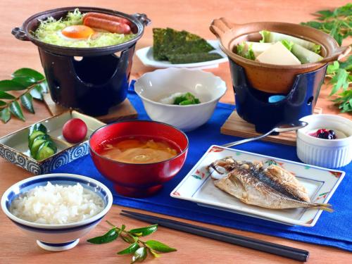 a table with a plate of food and bowls of food at Sports Plaza Shiki Haradaso in Myoko