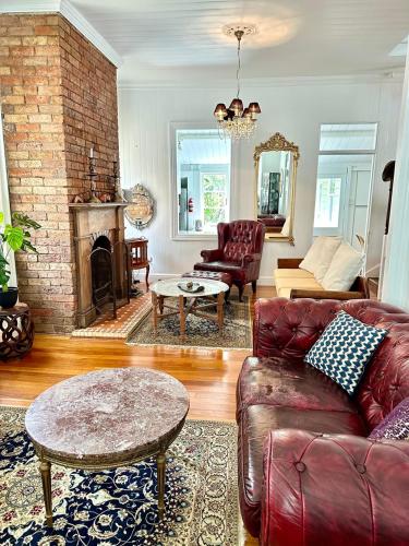 a living room with a couch and a fireplace at Charming heritage house in the heart of the city in Brisbane