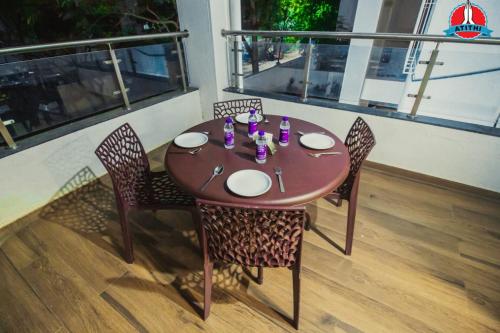 a wooden table with chairs and a table and a window at Atithi Service Apartment in Pune