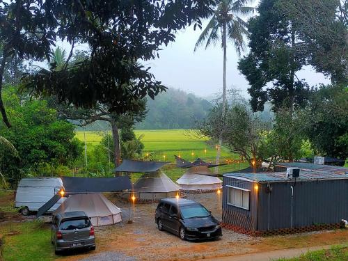 a group of tents and cars parked in a parking lot at Tanah Merah Glamping Village (TMGV) in Kuala Kangsar