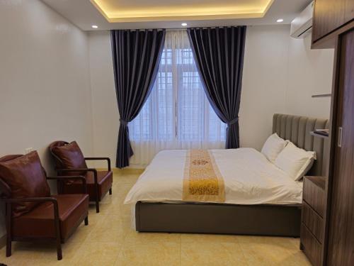 sypialnia z łóżkiem, krzesłem i oknem w obiekcie 4L HOTEL KIM BÔI w mieście Làng Trang