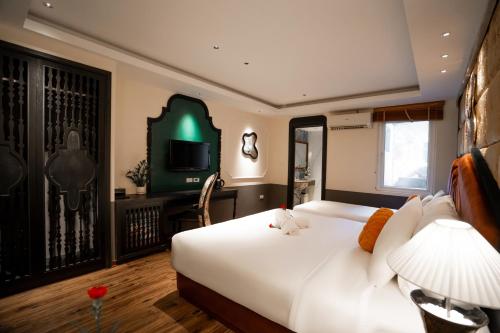 a bedroom with a large white bed and a television at Hanoi Center Silk Classic Hotel & Travel in Hanoi