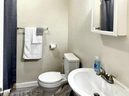 y baño con aseo blanco y lavamanos. en Cozy 2br House Near Paseo Art District Terry A en Oklahoma City