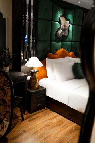 a bedroom with a bed with a guitar on the wall at Hanoi Center Silk Classic Hotel & Travel in Hanoi
