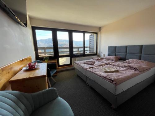 ein Schlafzimmer mit einem Bett, einem Sofa und einem Fenster in der Unterkunft Romanka in Żabnica